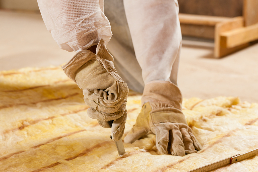 man cutting insulation material for building